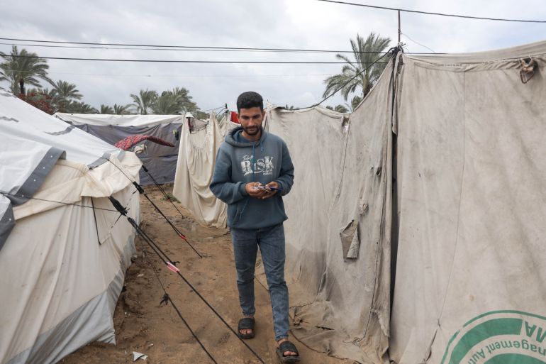 Gazans use drained phones as their only light source in darkness.